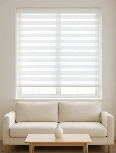 White zebra double roller blind on a window above a cream sofa