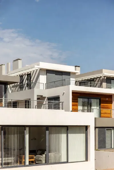 Vertical blinds in the ground-floor windows of a modern white house