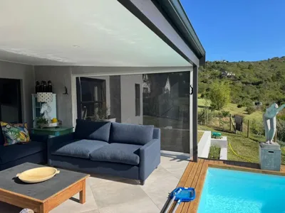 Mesh outdoor blinds lowered around a covered verandah dining area, Custom Blinds Shutters & Awnings