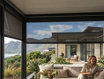 Screen outdoor blinds in side tracks on a louvred-roof patio with mountain and sea views