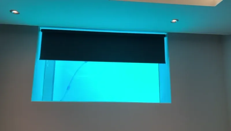 A blockout roller blind raising to reveal a lit underwater pool viewing window