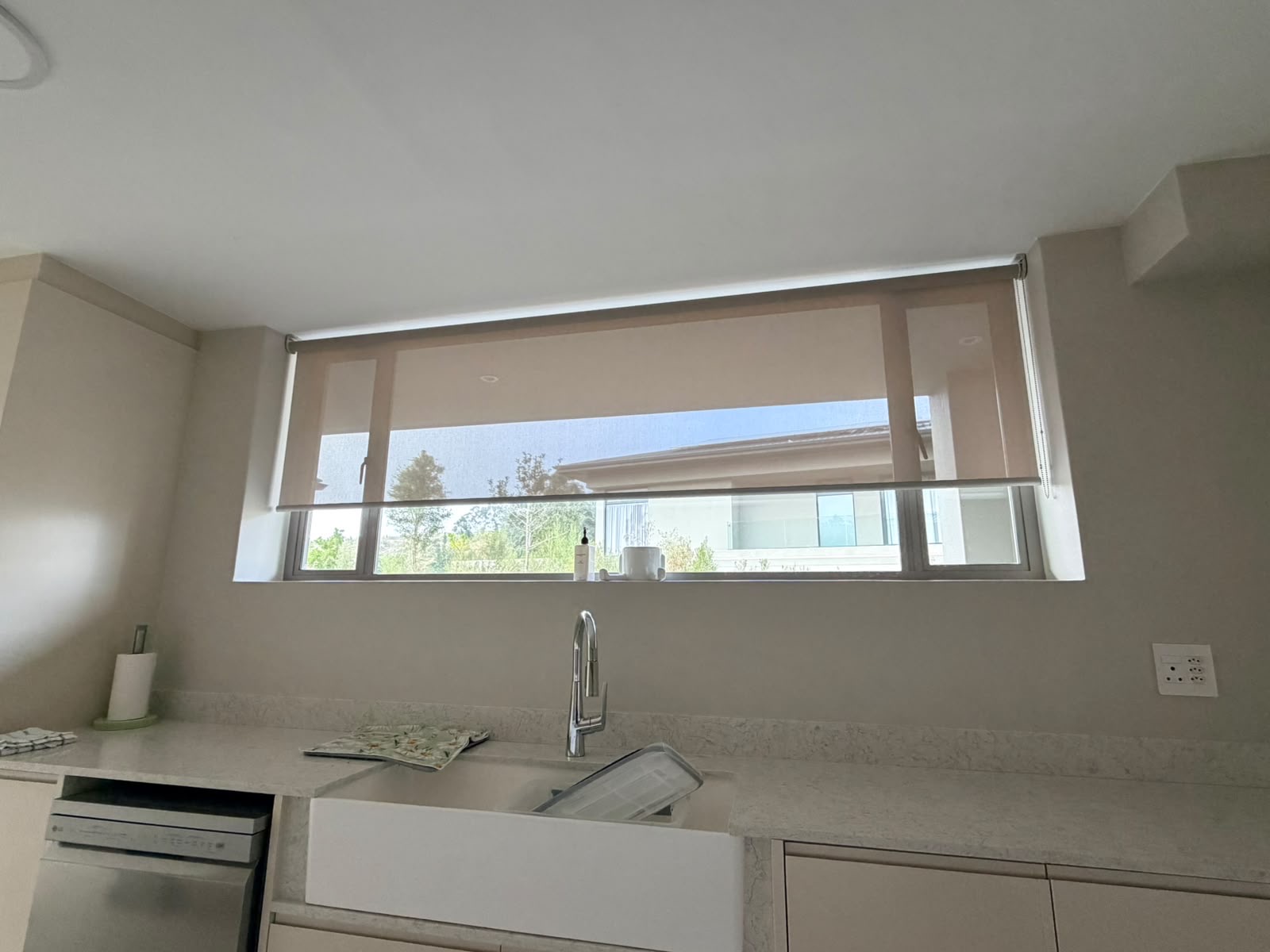 Dune Grey sheer roller blind on kitchen window above sink