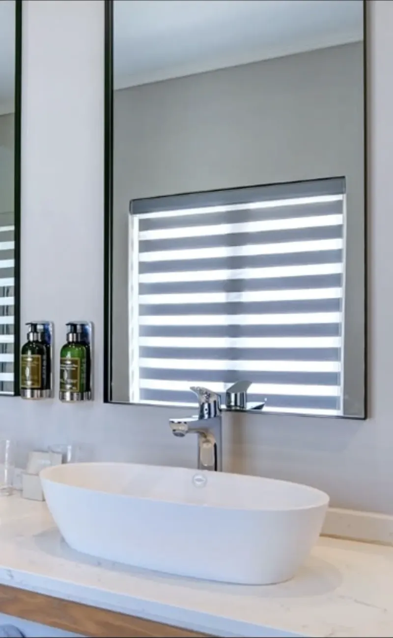 White Florence zebra double roller blind by Custom Blinds Shutters & Awnings in a luxury bathroom with a vessel basin